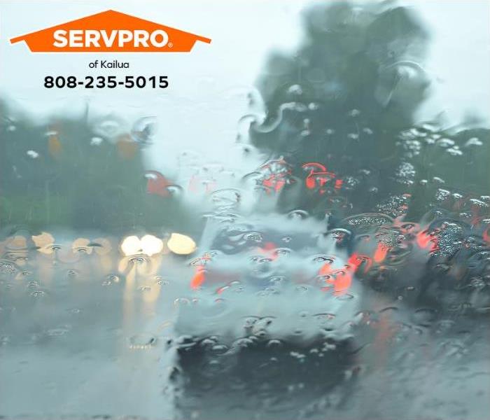 Heavy rain obscures the view of cars driving on the highway.