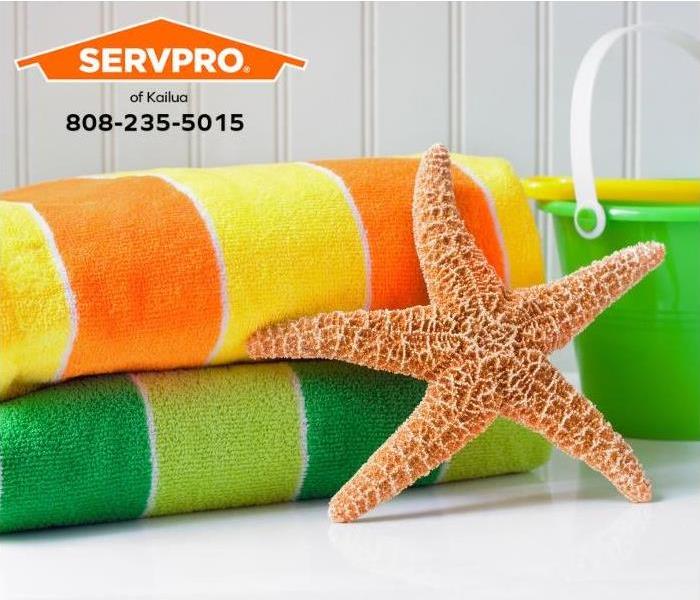 Clean and brightly colored beach towels sit on a shelf with a starfish.